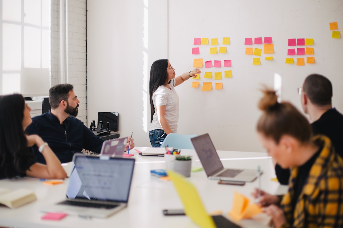 Facilitator mapping AI governance framework on whiteboard with senior executives